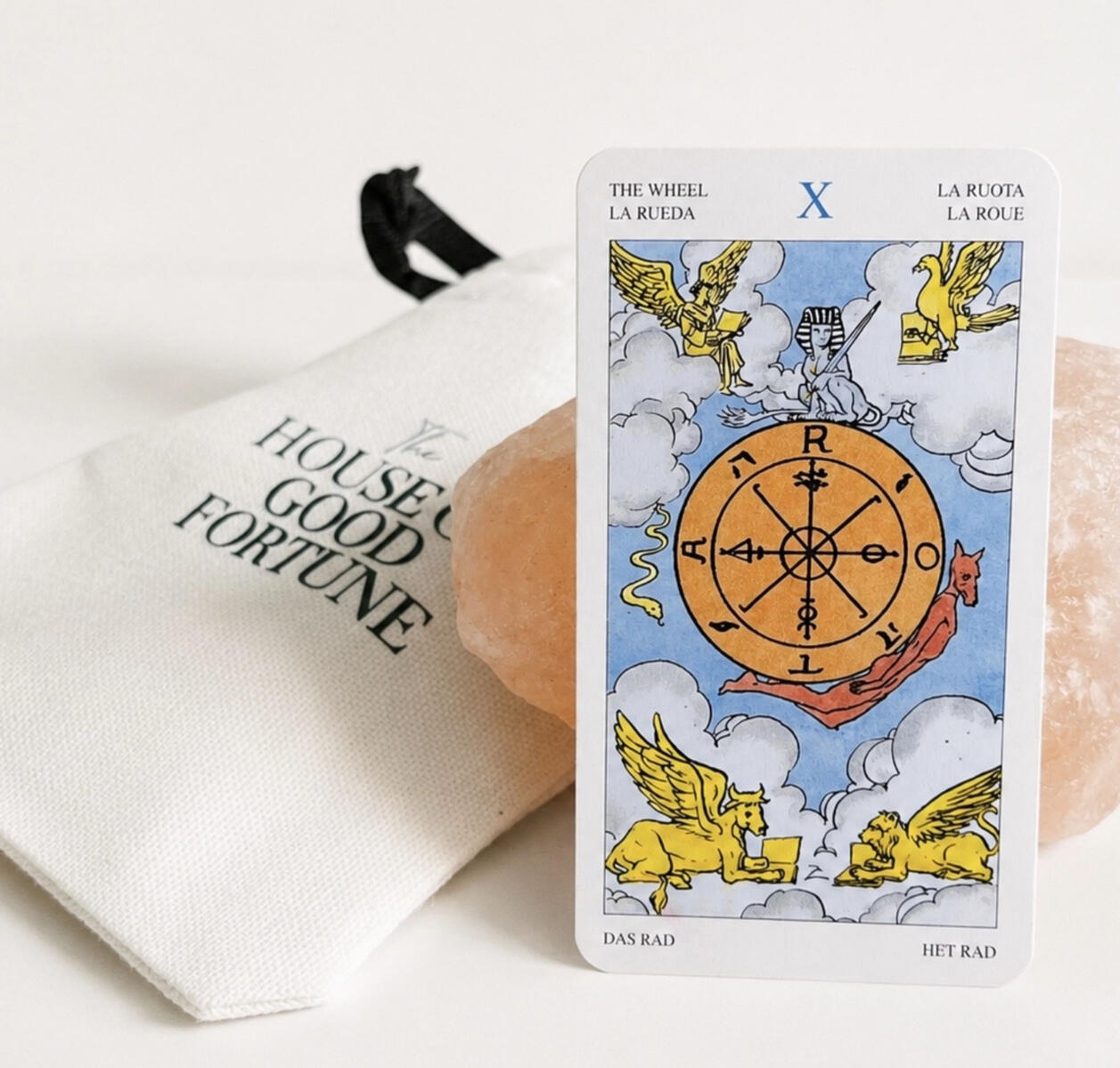 A tarot card resting on The House of Good Fortune crystal pouch